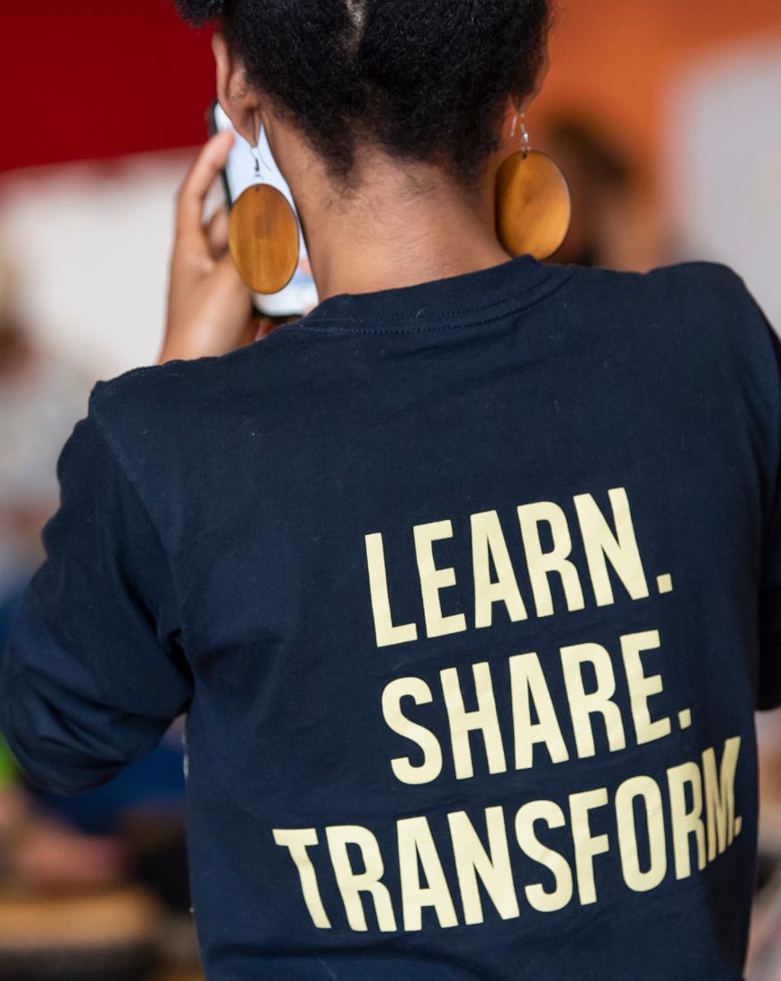 Presenter wearing a learn, share, transform t-shirt